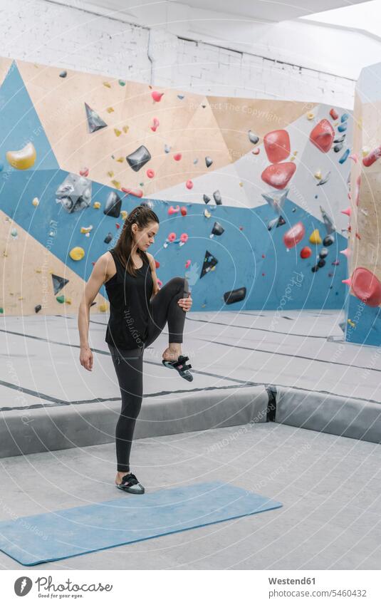 Frau bei Dehnungsübungen vor dem Klettern (value=0) steigen ausüben trainieren Übung stehend steht Muße beweglich Biegsamkeit Waende Wände drinnen