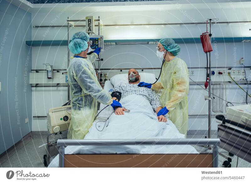 Ärzte, die Patienten auf der Notfallstation eines Krankenhauses betreuen, schauen auf den Bildschirm Leute Menschen People Person Personen Europäisch Kaukasier