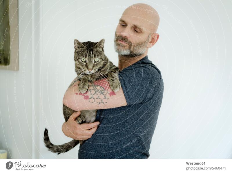 Tätowierter Mann trägt seine Katze tätowiert halten Katzen Zuhause zu Hause daheim Tattoo Tätowierungen Tatoos Taetowierung Tattoos Taetowierungen Haustier