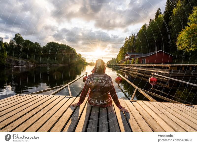 Finnland, Kajaani, Mann sitzt auf Steg, Sonnenuntergang beobachten, Rückansicht Entspannung relaxen entspannen Rueckansicht Rückenansicht Rueckenansicht