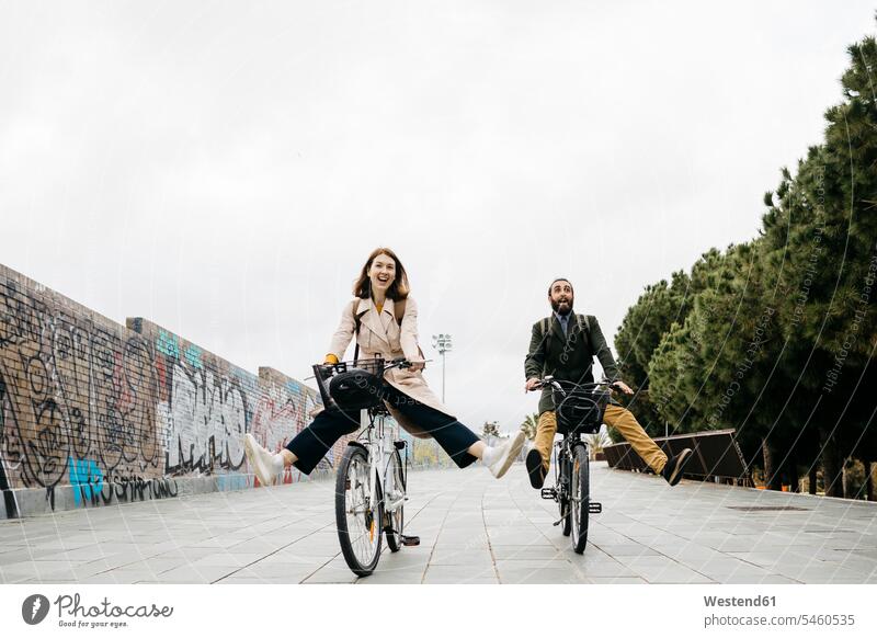 Unbeschwertes Paar fährt mit E-Bikes auf einer Promenade Promenaden Fahrrad Fahrräder Räder Rad fahren eBikes Elektrofahrrad Elektrorad Pärchen Paare