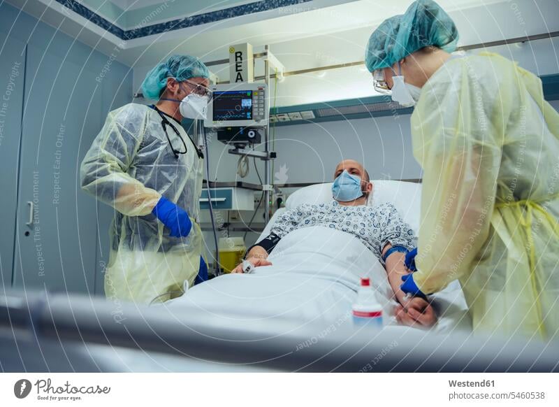 Ärzte, die Patienten auf der Notfallstation eines Krankenhauses betreuen und Blutproben entnehmen Leute Menschen People Person Personen Europäisch Kaukasier