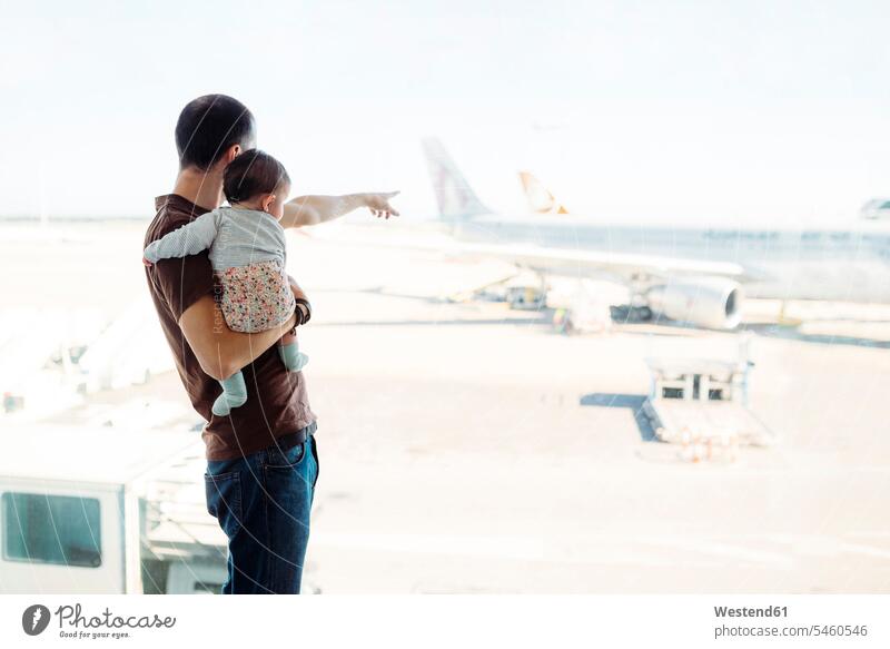 Spanien, Barcelona, Mann hält ein kleines Mädchen am Flughafen und zeigt auf die Flugzeuge Flughaefen Flugplätze Airport Flugplaetze Airports Terminals