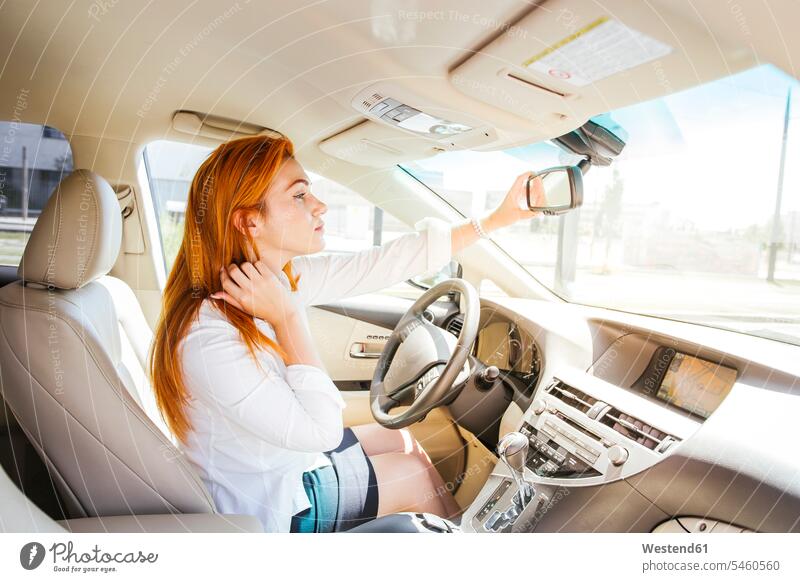 Geschäftsfrau in einem Auto, die ihren Blick in den Rückspiegel überprüft sehen sehend Schoenheit Schönheit drinnen Innenaufnahmen Leute Menschen People Person