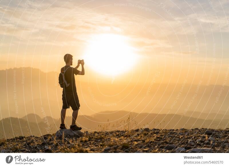 Spanien, Barcelona, Naturpark von Sant Llorenc, Mann wandert und fotografiert die Aussicht bei Sonnenuntergang wandern Wanderung Sonnenuntergänge fotografieren