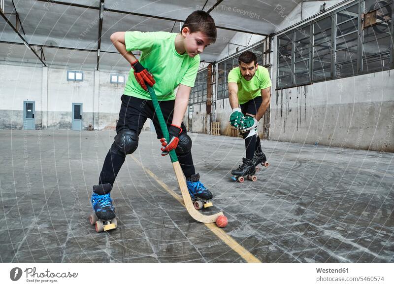 Junge übt Rollhockey mit Vater auf dem Platz Farbaufnahme Farbe Farbfoto Farbphoto Spanien Innenaufnahme Innenaufnahmen innen drinnen 10-11 Jahre