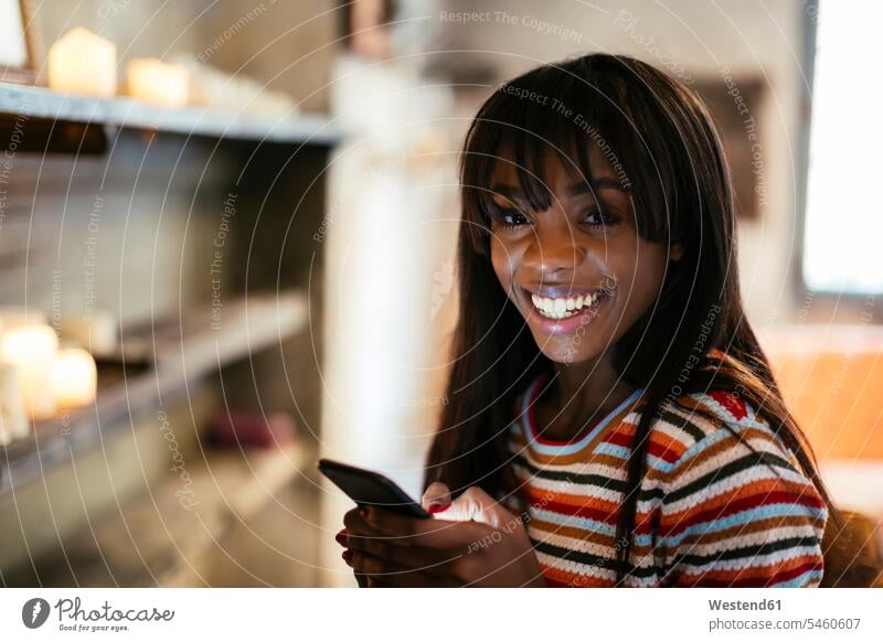 Porträt einer glücklichen jungen Frau mit Handy Glück glücklich sein glücklichsein Portrait Porträts Portraits Smartphone iPhone Smartphones weiblich Frauen