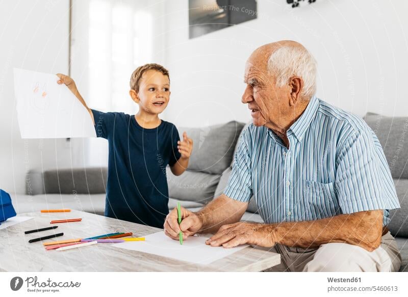 Großvater und Enkel zeichnen mit Buntstiften im Wohnzimmer Zeichnung Opa Großpapa Großpapas Opas Opi Großväter Opis Wohnraum Wohnung Wohnen Wohnräume Wohnungen