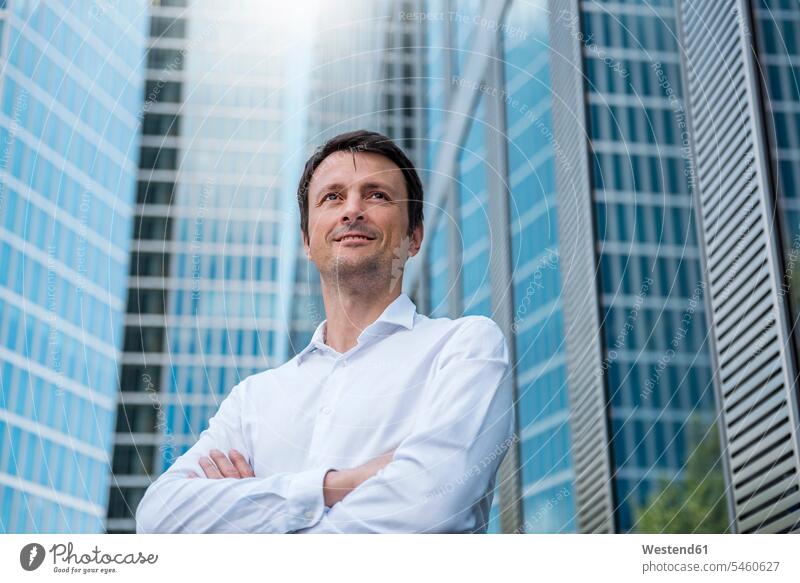 Porträt eines selbstbewussten Geschäftsmannes vor einem Wolkenkratzer Stadt staedtisch städtisch Portrait Porträts Portraits Hochhaus Skycrapers Hochhaeuser