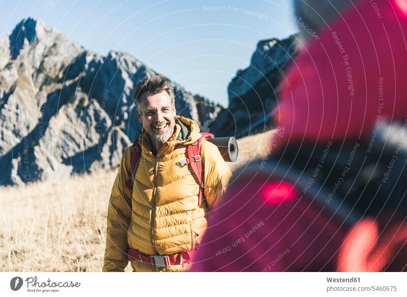 Österreich, Tirol, glücklicher Mann mit Frau beim Wandern in den Bergen wandern Wanderung Männer männlich Gebirge Berglandschaft Gebirgslandschaft Gebirgskette