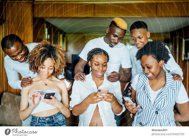 Familie und Freunde benutzen Mobiltelefone zu Hause Kameradschaft Telekommunikation telefonieren Handies Handys freuen Frohsinn Fröhlichkeit Heiterkeit Glück