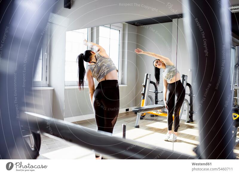 Frau übt im Fitnessstudio und schaut in den Spiegel trainieren Fitnessclubs Fitnessstudios Turnhalle weiblich Frauen schauen sehend fit Gesundheit gesund Sport