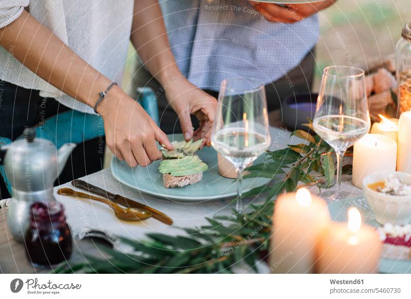 Nahaufnahme eines Paares bei der Zubereitung einer romantischen Mahlzeit bei Kerzenlicht im Freien schwärmerisch schwaermerisch gefuehlvoll gefühlvoll Romantik
