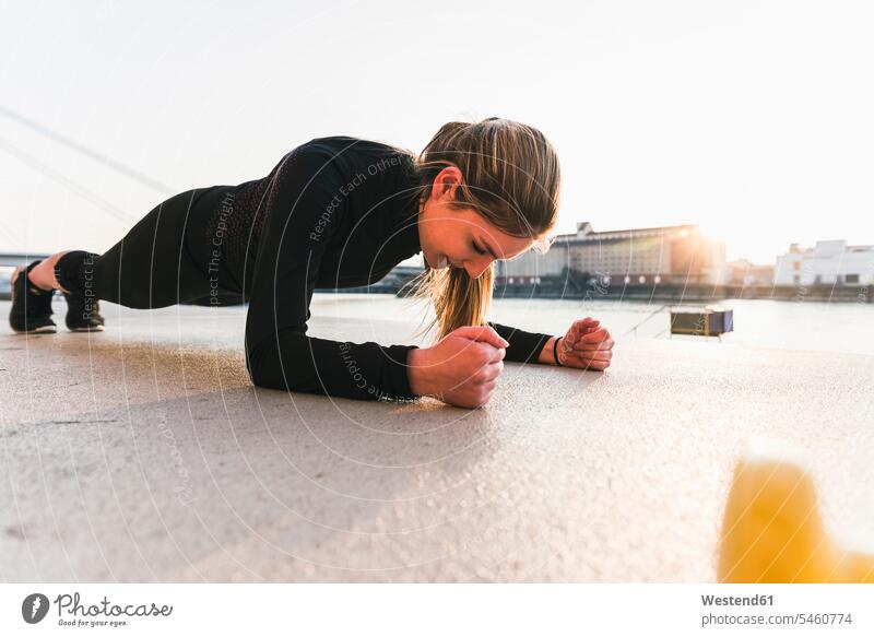 Junge Frau trainiert bei Sonnenuntergang in der Stadt staedtisch städtisch trainieren Sonnenuntergänge weiblich Frauen Außenaufnahme draußen im Freien Stimmung