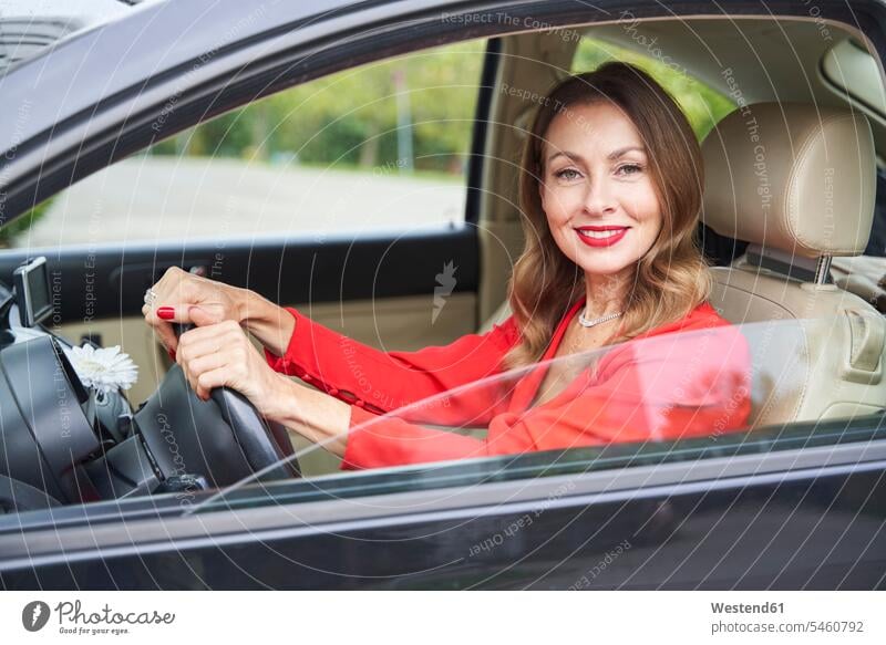Porträt einer lächelnden reifen Frau im Auto Kleider KFZ Verkehrsmittel Automobil Autos PKW PKWs Wagen Lenkraeder Lenkräder fahrend fahrende fahrender fahrendes