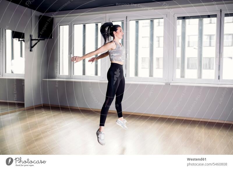 Frau macht eine Sprungübung im Fitnessstudio trainieren Fitnessclubs Fitnessstudios Turnhalle Übung Uebung Übungen Uebungen springen hüpfen weiblich Frauen fit