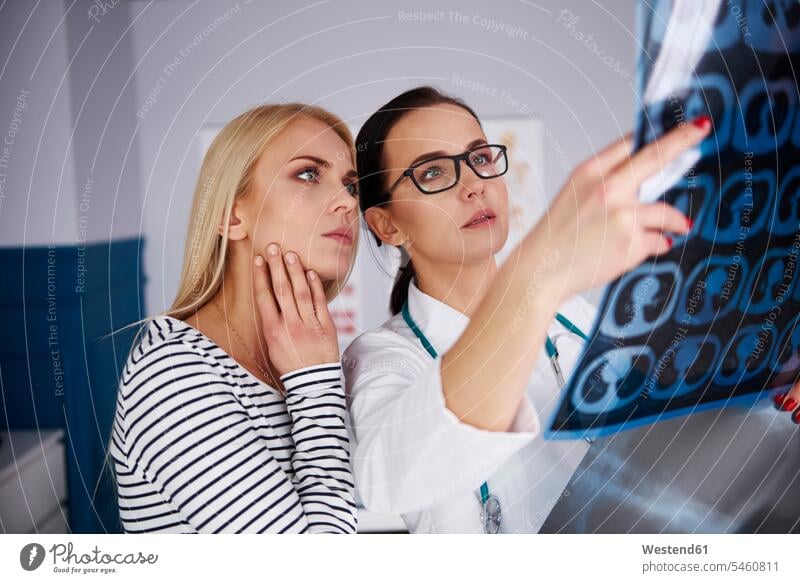 Arzt zeigt einer jungen Frau Röntgenbilder Roentgenbild Roentgenbilder weiblich Frauen Ärztin Aerztin Ärztinnen Doktorinnen Aerztinnen zeigen vorführen