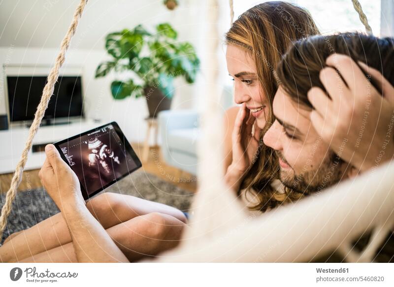 Glücklich liebevolles Paar Blick auf Ultraschall-Scan auf Tablette glücklich glücklich sein glücklichsein ansehen Zuneigung Tablet Computer Tablet-PC Tablet PC