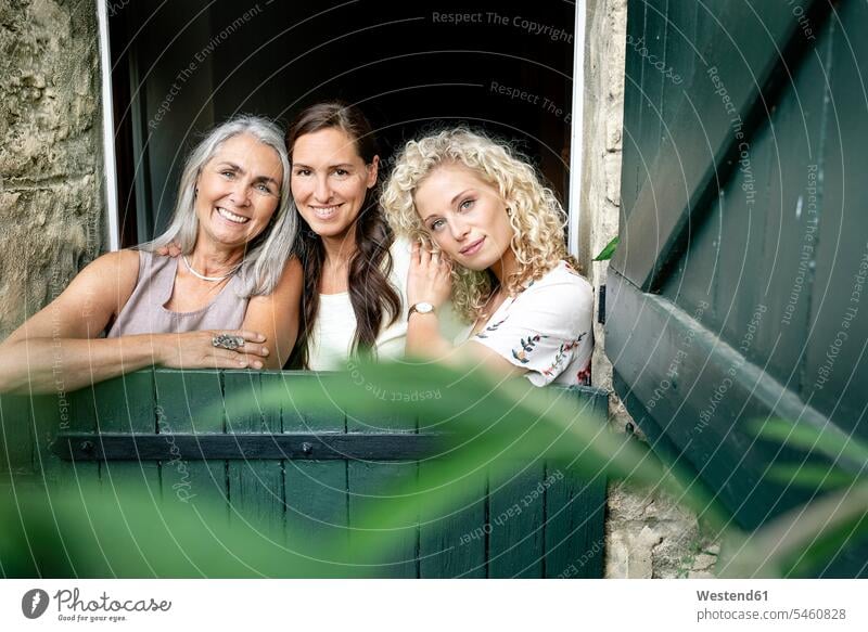 Porträt von drei lächelnden Frauen unterschiedlichen Alters hinter Stalltor Altersunterschied weiblich Portrait Porträts Portraits Tor Tore Stallung Stallungen