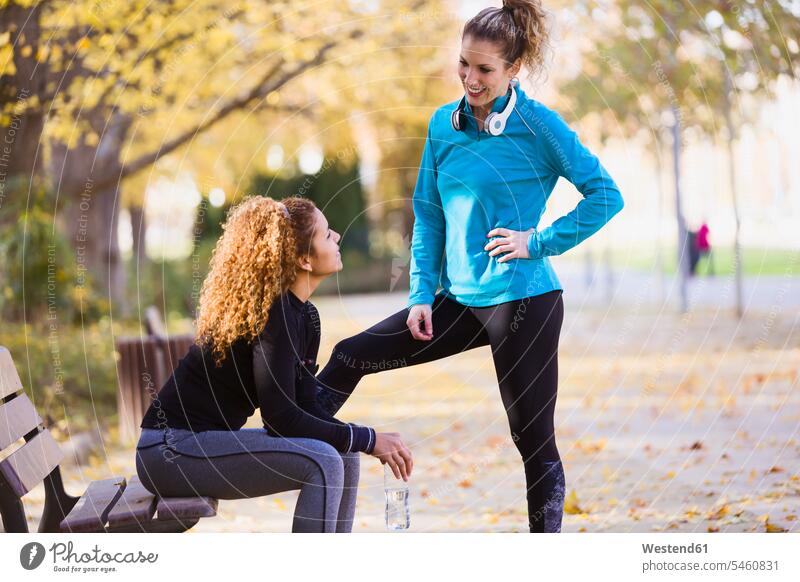Zwei sportliche junge Frauen unterhalten sich im Park weiblich Parkanlagen Parks sprechen reden Freundinnen Erwachsener erwachsen Mensch Menschen Leute People