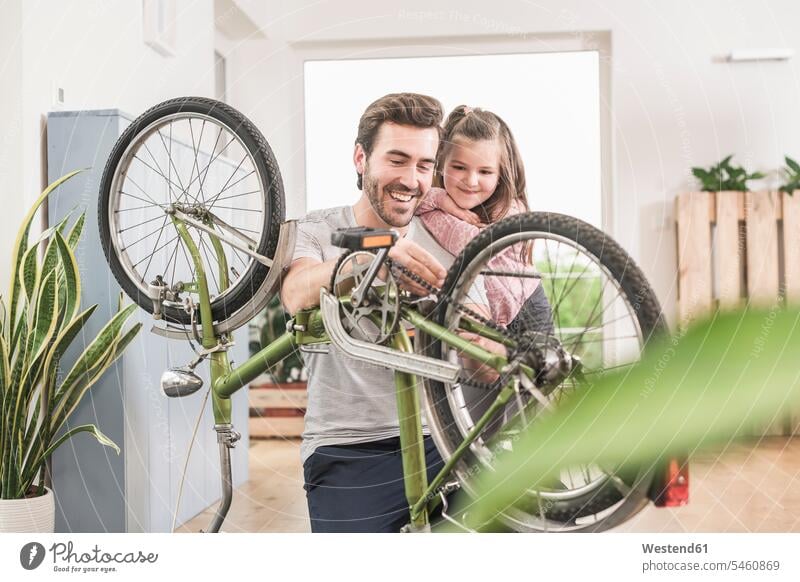 Junger Mann und kleines Mädchen reparieren Fahrrad zusammen Deutschland Quality Time alleinerziehender Vater zeigen vorführen präsentieren Vorführung herzeigen