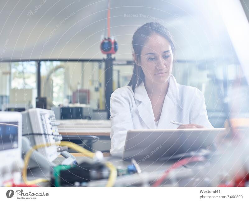 Im Forschungslabor arbeitende Technikerin, die mit dem Stift auf einem Tablett zeichnet Eingabestift Ingenieurin Ingenieurinnen Tablet Computer Tablet-PC