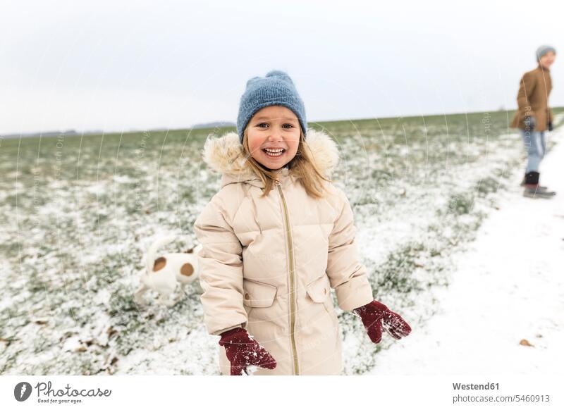 Porträt eines glücklichen Mädchens mit Hund und Bruder in einer Winterlandschaft winterlich Winterzeit Winterlandschaften Hunde Glück glücklich sein