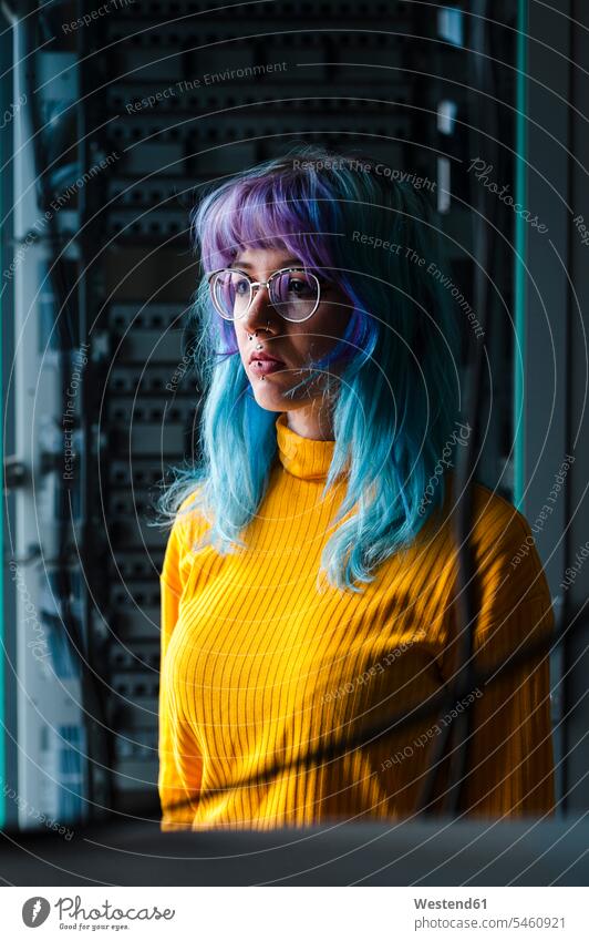 Nahaufnahme einer nachdenklichen jungen Frau mit gefärbten Haaren und Piercings in einem alten Büro Farbaufnahme Farbe Farbfoto Farbphoto Innenaufnahme