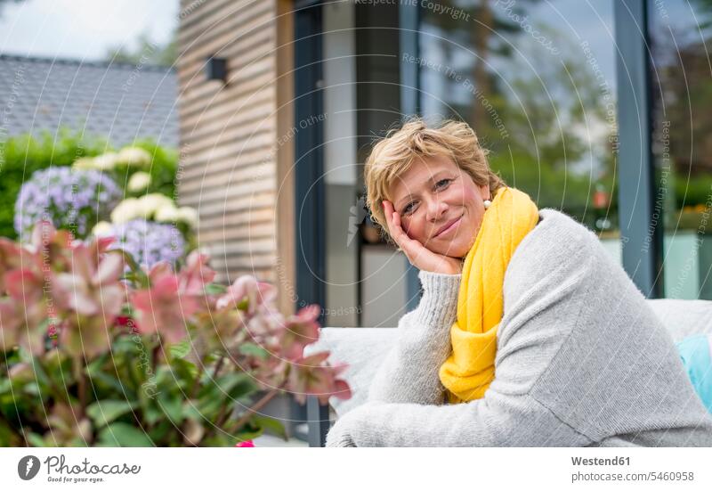Porträt einer lächelnden Frau, die sich zu Hause auf der Terrasse entspannt Leute Menschen People Person Personen Alleinstehende Alleinstehender Singles