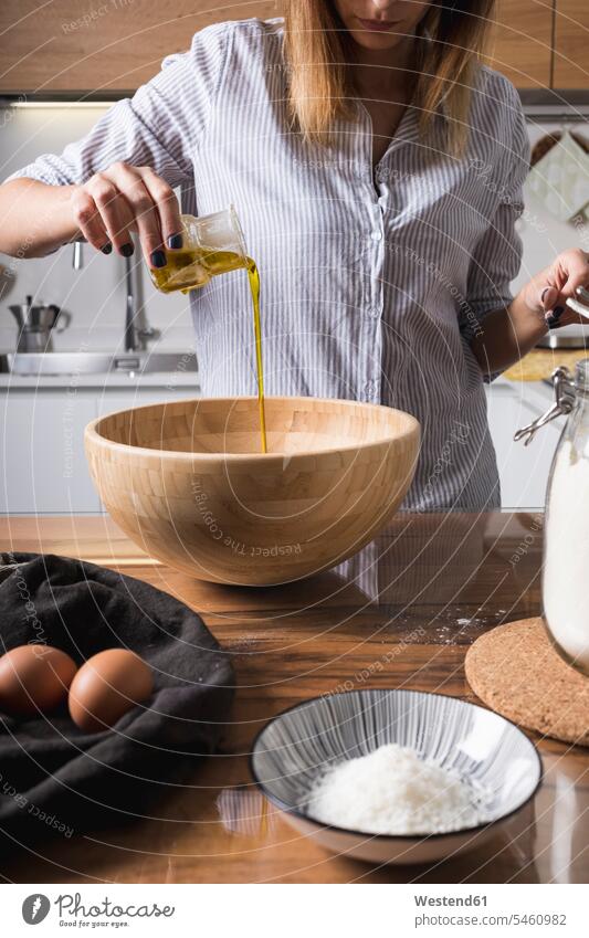 Frau gießt Öl in Holzschüssel zubereiten kochen Essen zubereiten Rührschüssel schütten gießen Zubereitung backen Öle Schüssel Schalen Schälchen Schüsseln Food