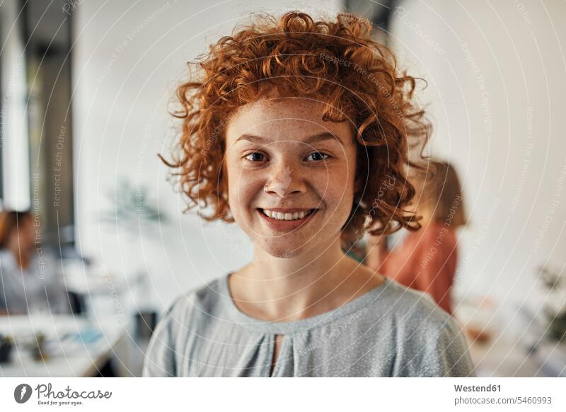 Porträt einer lächelnden rothaarigen Geschäftsfrau im Amt Arbeitskollege Arbeitskollegen Kollege Job Berufe Berufstätigkeit Beschäftigung Jobs geschäftlich