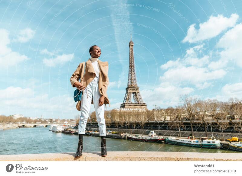 Frankreich, Paris, Lächelnde Frau steht auf einer Brücke mit dem Eiffelturm im Hintergrund Fluss Fluesse Fluß Flüsse weiblich Frauen Bruecken Brücken Touristin