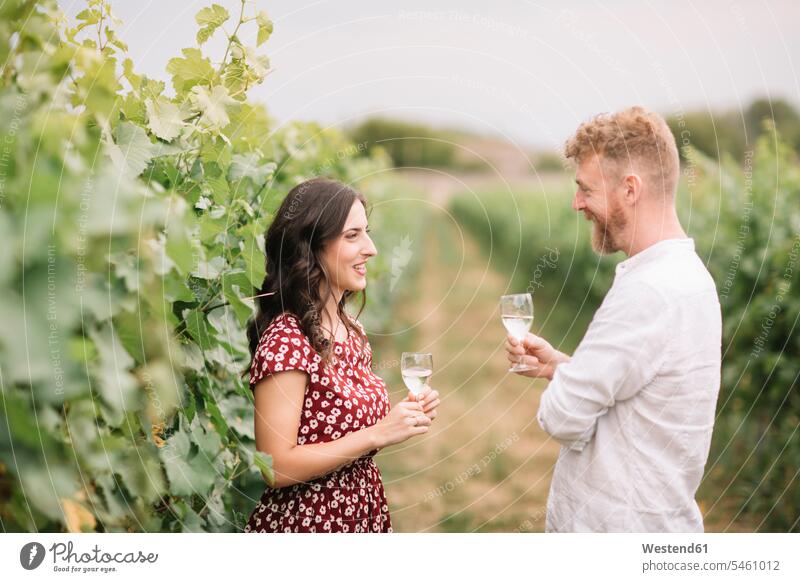 Ehepaar trinkt Weißwein in den Weinbergen reden freuen Glück glücklich sein glücklichsein stehend steht auf dem Land auf dem Lande Muße Gespraech Gespraeche