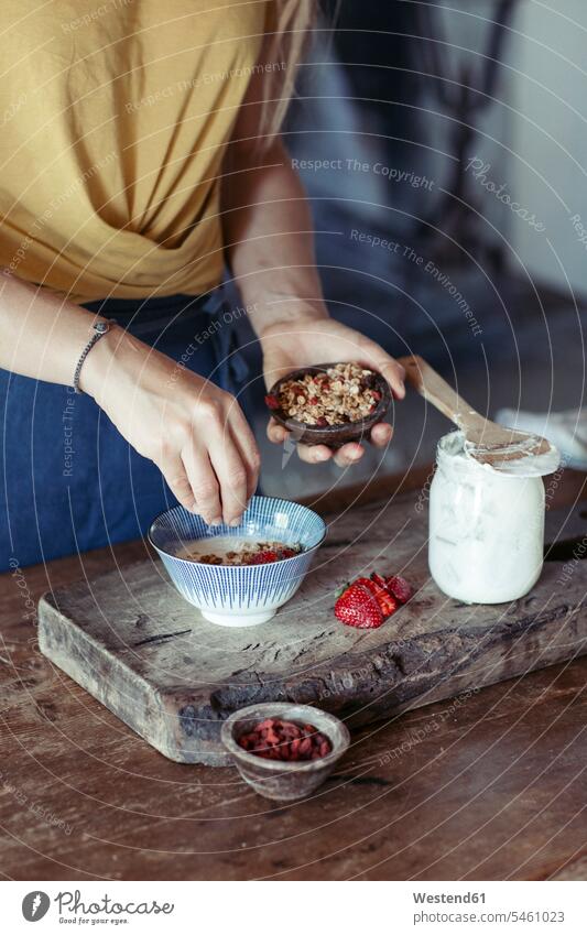 Frau bereitet Müsli zu weiblich Frauen zubereiten kochen Essen zubereiten selbstgemacht selbstgemachte hausgemacht Erdbeere Erdbeeren Fragaria Muesli Joghurt