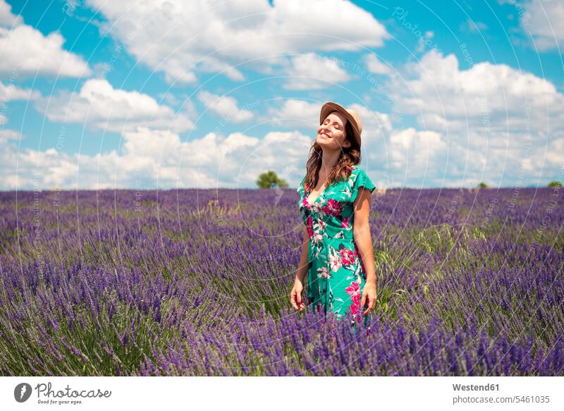 Frankreich, Provence, Valensole-Plateau, glückliche Frau mit Strohhut im Lavendelfeld stehend Strohhüte Strohhuete weiblich Frauen steht genießen geniessen