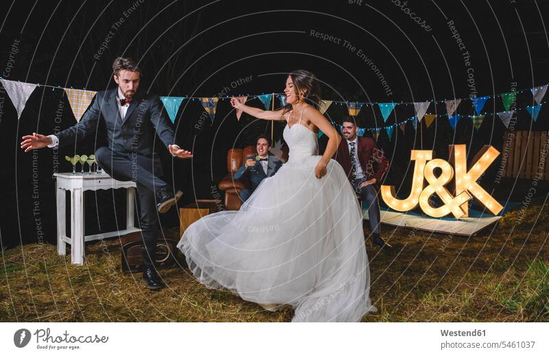 Glückliche Braut und Mann tanzen auf einer nächtlichen Feldfeier Felder glücklich glücklich sein glücklichsein Hochzeit heiraten Heirat Hochzeiten tanzend