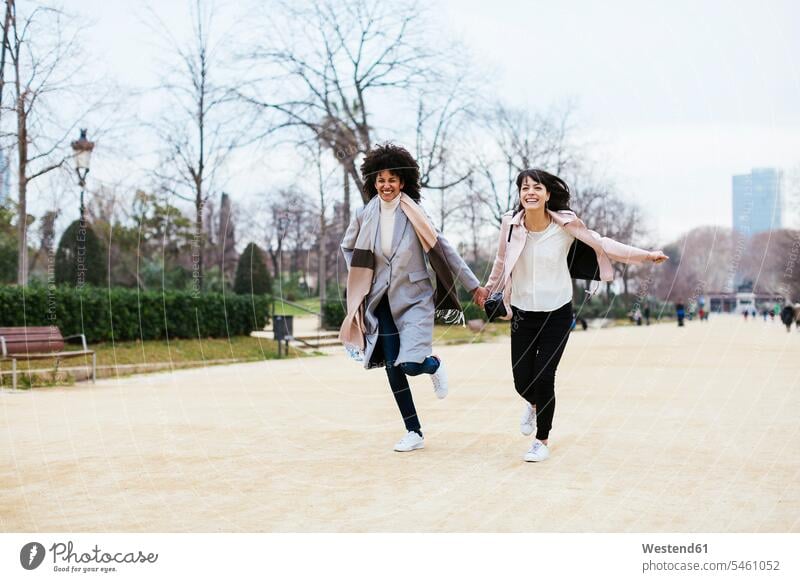 Spanien, Barcelona, zwei überschwängliche Frauen laufen im Stadtpark Freundinnen weiblich Park Parkanlagen Parks staedtisch städtisch glücklich Glück