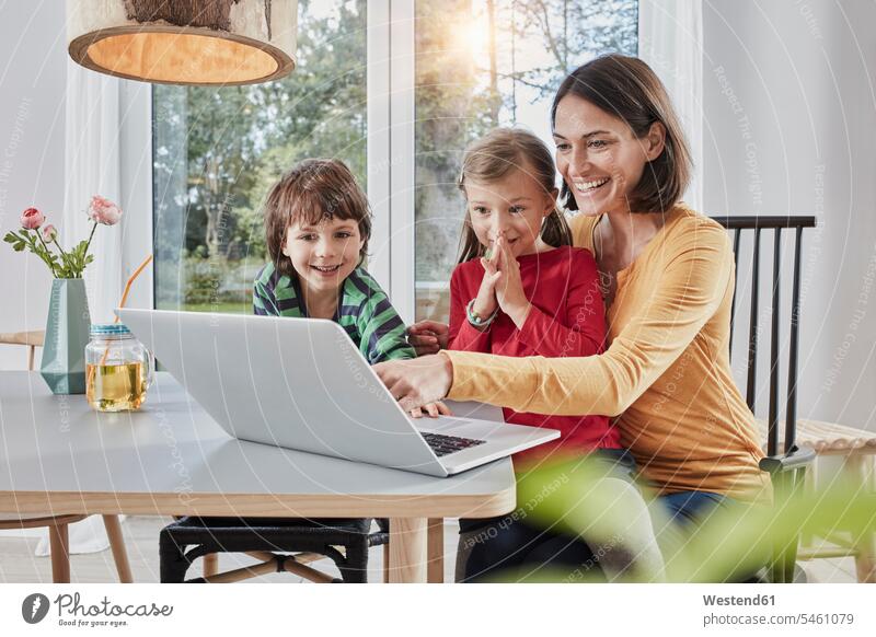 Glückliche Mutter mit zwei Kindern mit Laptop zu Hause Mami Mutti Mütter Mama Notebook Laptops Notebooks glücklich glücklich sein glücklichsein Zuhause daheim