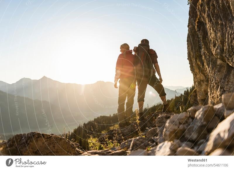 Paar stehend auf einem Berg, Blick auf Aussicht Rucksack Rucksäcke steht Pärchen Paare Partnerschaft Fels Felsen bergsteigen Bergsteiger wandern Wanderung