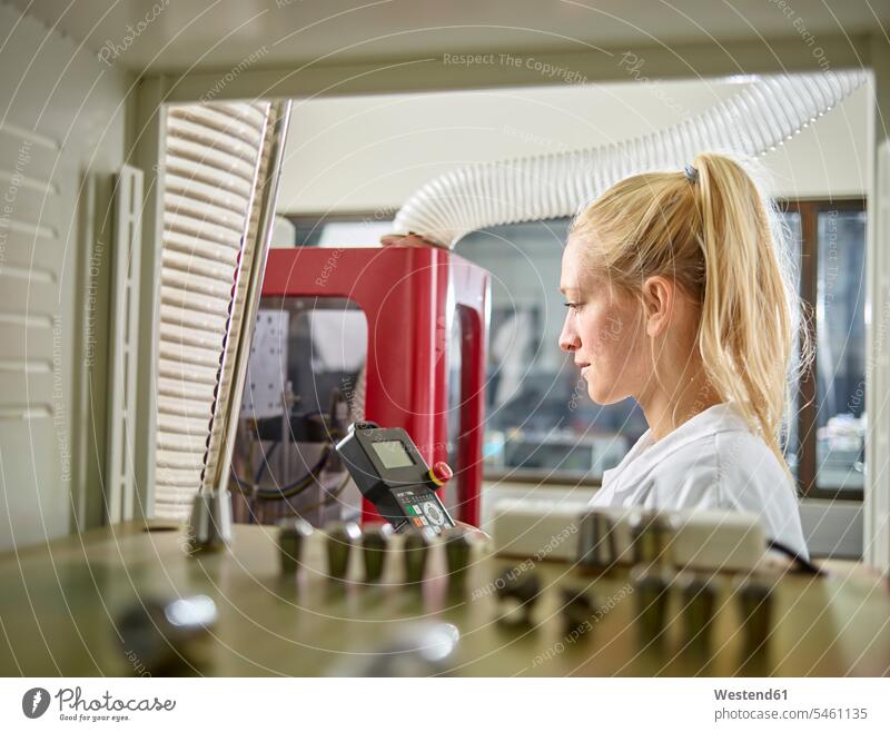 Technikerin, die eine CNC-Maschine wartet Frau weiblich Frauen arbeiten Arbeit Industrie industriell Gewerbe Industrien Technikerinnen CNC-Maschinen Erwachsener