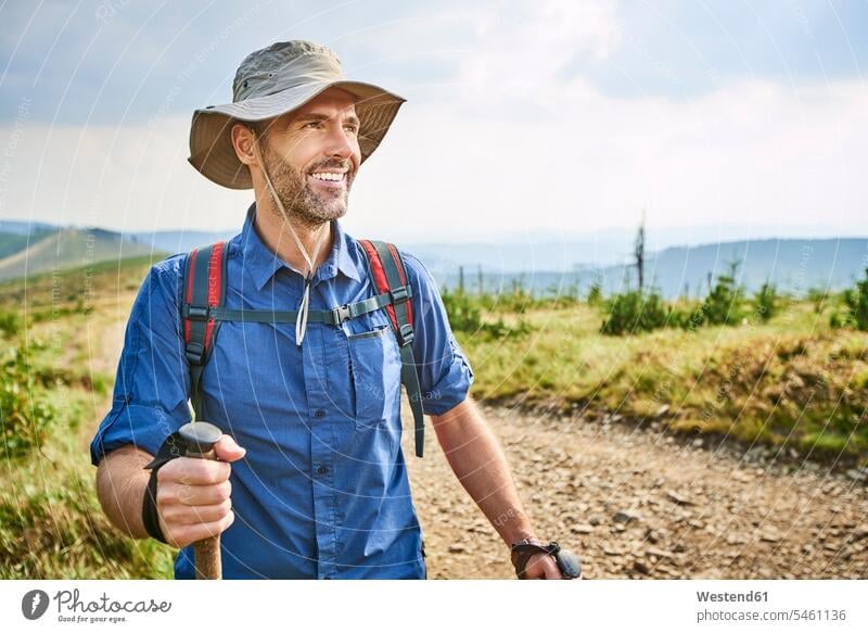 Porträt eines lächelnden Mannes beim Wandern in den Bergen Portrait Porträts Portraits Gebirge Berglandschaft Gebirgslandschaft Gebirgskette Gebirgszug wandern