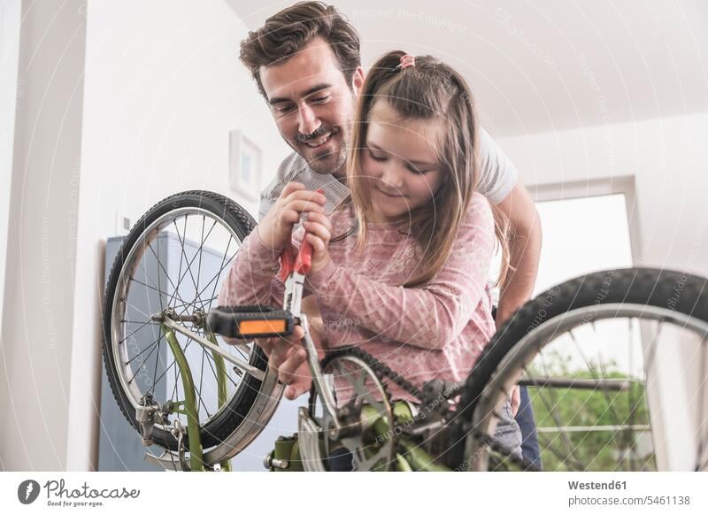 Junger Mann und kleines Mädchen reparieren Fahrrad zusammen Deutschland alleinerziehender Vater zeigen vorführen präsentieren Vorführung herzeigen