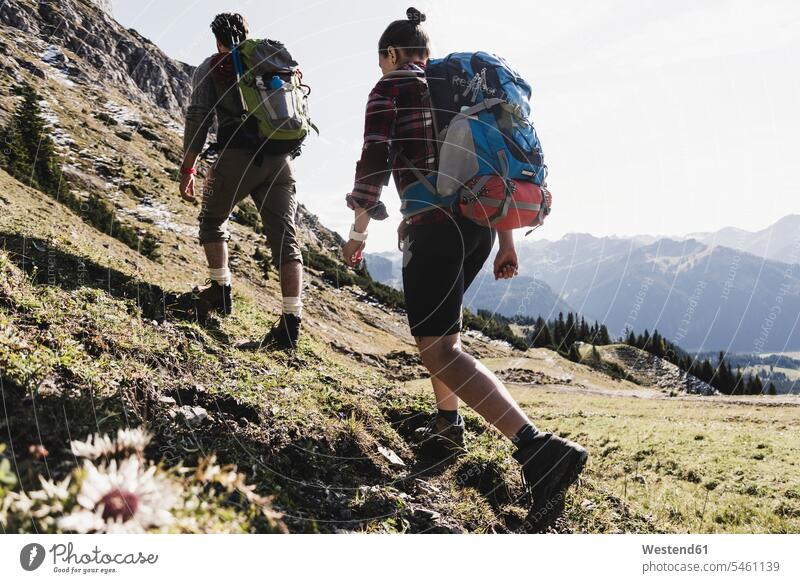 Österreich, Tirol, junges Paar beim Wandern in den Bergen Gebirge Berglandschaft Gebirgslandschaft Gebirgskette Gebirgszug wandern Wanderung Pärchen Paare