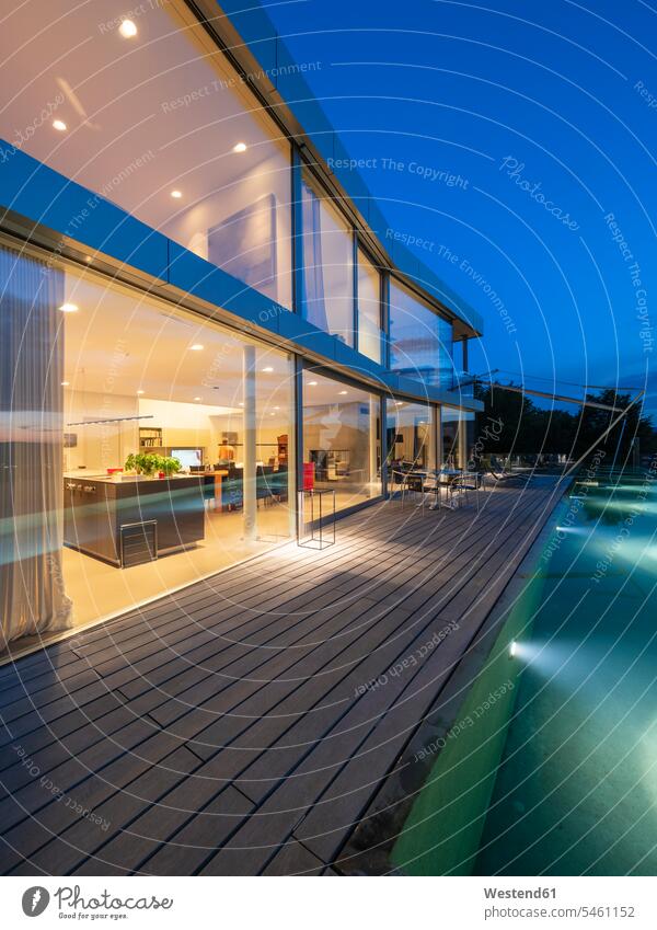 Schweiz, beleuchtete moderne Villa in der Abenddämmerung mit Terrasse und Pool im Vordergrund Fassade Gebäudefront Fassaden Glasfront Glasfronten Glasfassade