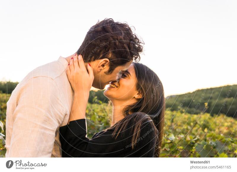 Italien, Toskana, Siena, glückliches junges Paar, das sich in einem Weinberg küsst küssen Küsse Kuss Weingaerten Weingarten Weingärten Weinberge Pärchen Paare