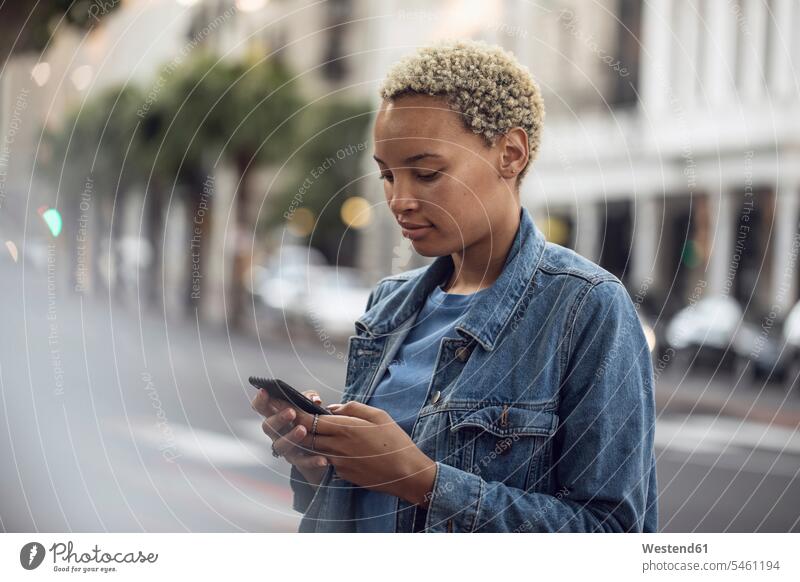 Junge Frau mit Smartphone in der Stadt Leute Menschen People Person Personen Afrikanisch Afrikanische Abstammung dunkelhäutig Farbige Farbiger Schwarze