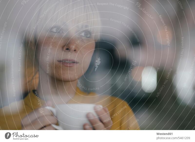 Porträt einer schönen blonden Frau, die am Fenster steht und Kaffee trinkt Zuversicht Zuversichtlich Selbstvertrauen selbstbewusst Vertrauen Portrait Porträts