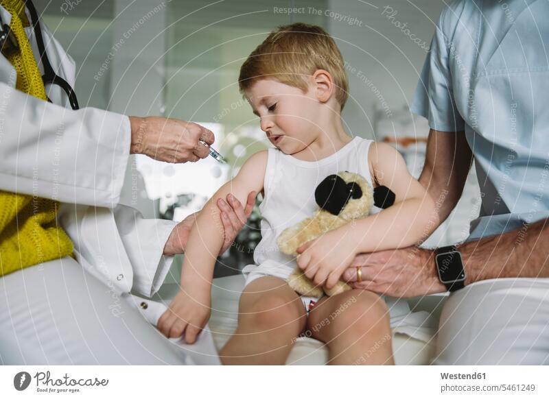 Kinderarzt injiziert Impfstoff in den Arm eines unglücklichen Kleinkindes Gesundheit Gesundheitswesen medizinisch Erkrankung Erkrankungen Krankheiten Kranke