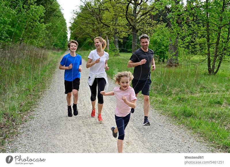 Kinder rennen mit den Eltern auf einem Feldweg inmitten von Bäumen und Pflanzen im Wald Farbaufnahme Farbe Farbfoto Farbphoto Deutschland Wälder Forst Natur
