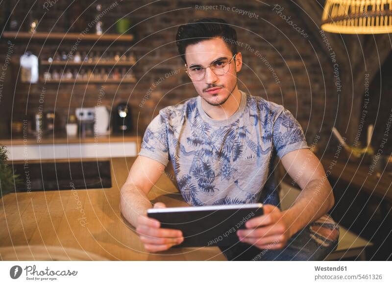 Porträt eines jungen Mannes, der zu Hause in der Küche Tabletten benutzt Männer männlich Tablet Computer Tablet-PC Tablet PC iPad Tablet-Computer Portrait